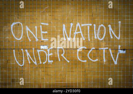 Grungy Graffiti On A Wall In The UK Saying One Nation Under CCTV Stock Photo