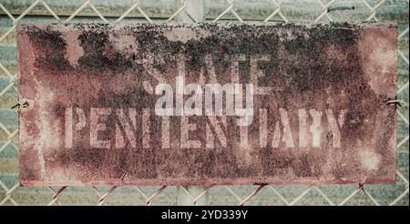 Retro Filtered Photo Of Rusty Grungy Old Penitentiary Prison Sign On Chain Link Fence Stock Photo