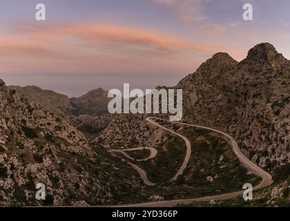 Colourful sunrise in the Tramuntana mountains of Mallorca with a view of the landmark snake road leading down to Sa Calobra Stock Photo