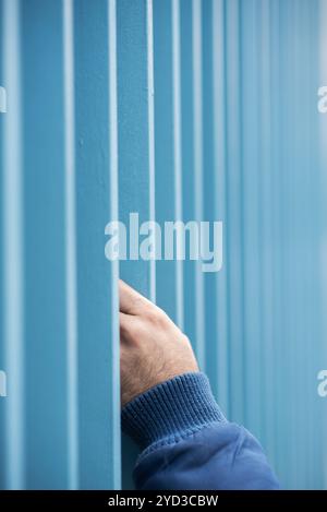 Mans hand over bars Stock Photo