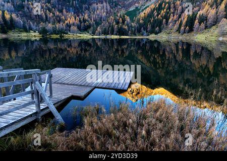 Wooden floating platform at Duisitzkarsee lake, alpine lake near Schladming in austrian alps, reflection of the mountains in the lake, autumn foliage Stock Photo