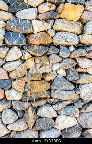 Stone wall with metal grid as background Stock Photo