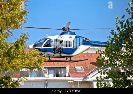 Police sniper in helicopter urban area low flight view Stock Photo