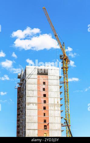 New tall apartment building under construction with crane Stock Photo