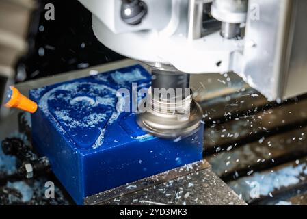 Metalworking CNC lathe milling machine with coolant. Milling  a piece of plastic. Industrial metalworking cutting process on cnc machine. Milling tool Stock Photo