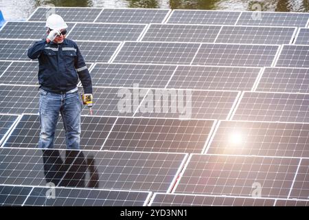 Professional Engineer Service Floating Solar Panel. Worker Maintenance Cleaning Replacing Solar Panel. Solar photovoltaic panel system in Industry lak Stock Photo