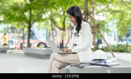 Business people hand typing at laptop computer keyboard. Businesswomen outdoor working at green city background. Stock Photo