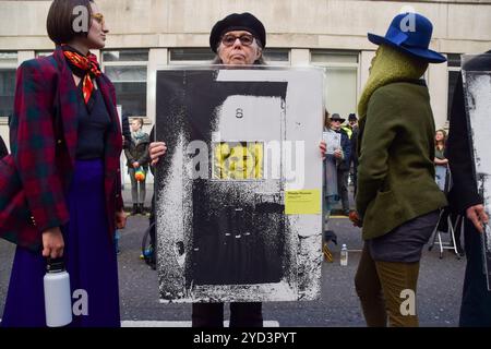 London, UK. 24th October 2024. A protester holds a picture of Just Stop Oil activist Phoebe Plummer as activists stage the ‘Free Political Prisoners’ protest exhibition outside the Ministry of Justice in London, calling on the Attorney General to free the climate activists and other protesters currently in UK prisons. The protesters taking part in the exhibition blocked the road outside the MOJ with pictures of activists in jail and of other political prisoners. Credit: Vuk Valcic/Alamy Live News Stock Photo