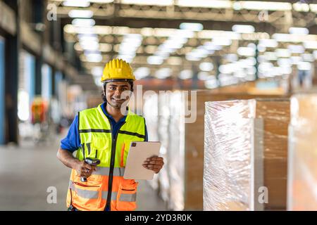 Portrait Happy Indian male worker inventory barcode check. Warehouse staff in safety work in factory cargo warehouse. Stock Photo