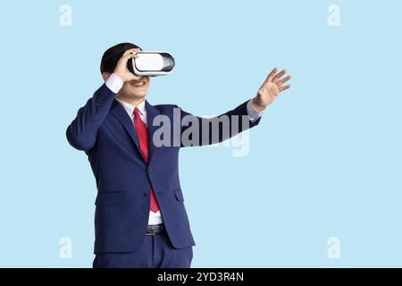 businessman using visual VR technology isolated on blue background, business people using modern hologram technology device. Stock Photo