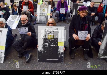 London, UK. 24th October 2024. A protester holds a picture of Roger Hallam as activists stage the ‘Free Political Prisoners’ protest exhibition outside the Ministry of Justice in London, calling on the Attorney General to free the climate activists and other protesters currently in UK prisons. The protesters taking part in the exhibition blocked the road outside the MOJ with pictures of activists in jail and of other political prisoners. Credit: Vuk Valcic/Alamy Live News Stock Photo