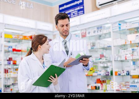 Pharmacy working people team stuff standing talking together in drugstore, Pharmacist male and female working cooperate. Stock Photo
