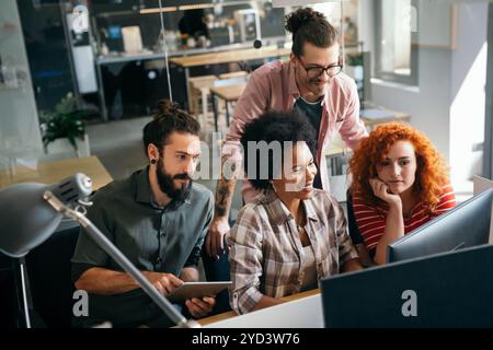 Mixed team of software engineers brainstorming ideas. Diverse app developers collaborating as group Stock Photo