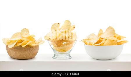 Potato chips into different bowls on white table. Stock Photo