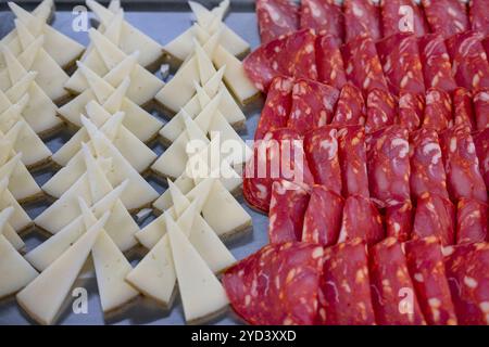 Catering platter prepared for an event with typical Spanish charcuterie ingredients: Manchego cheese cut in triangular shapes and slices of chorizo Stock Photo