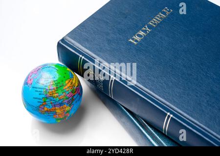 Book of Holy Bible with globe. It is laying on white background. Symbol of faith and worship in God. Religious christian service, missionary, holiday Stock Photo