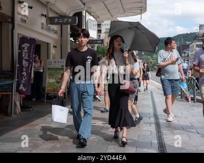A young couple walk hand in hand on a shopping street in Kyoto, Japan. Stock Photo