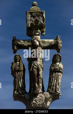 Calvary, dating from the 1400s, in the parish close (enclos paroissial), Church of Saint Nonne, Dirinon, Finistère, Brittany, France. Christ on the cross is flanked by the Virgin Mary and Saint John the Evangelist. Stock Photo