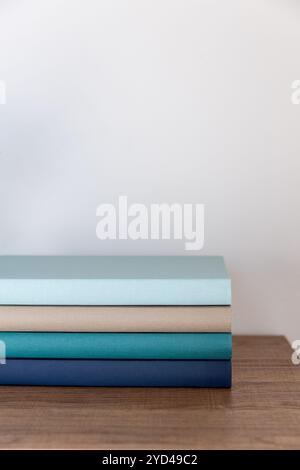 Neatly stacked colorful books on a wooden surface Stock Photo
