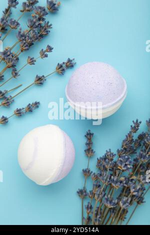 Natural cosmetics. Handmade lavender bath bombs and lavender flowers on blue background. Vertical photo. Stock Photo