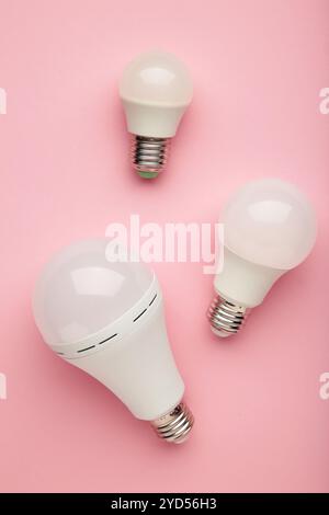 Comparison of different light bulbs on pink background. Top view Stock Photo
