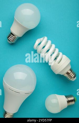 Comparison of different light bulbs on blue background. Top view Stock Photo