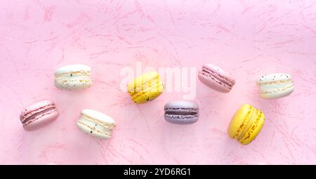 Sweet macaroons macarons on pink background. French cookies with vanilla, raspberry, lemon and strawberry. Stock Photo