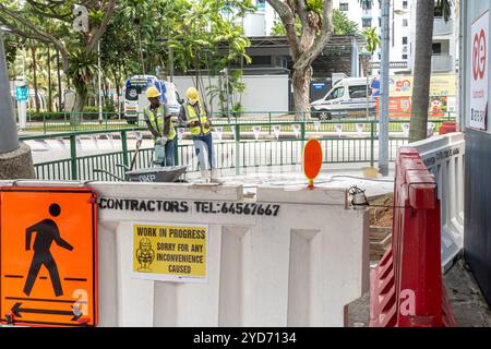 Road works, workers, in Marine Parade, Singapore, "Work in progress" sign Stock Photo