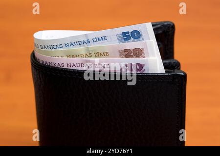 Latvian lats in the black wallet Stock Photo