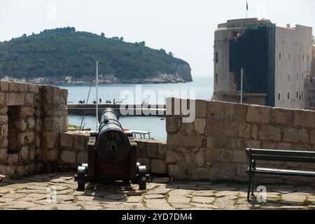 The view from vantage point at the side of Fort Revelin, after the Ploce Gate entrance to the walled old city. Dubrovnik. Croatia. An original cannon artillery piece gun is on display, pointing towards Lokrum Island. (138) Stock Photo