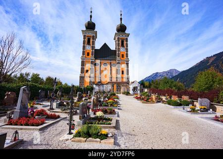 Majestic Catholic Cathedral and Cemetery. Travel to Austria. Scenic roads in the Austrian Alps. Mountains and dense coniferous forests. Stock Photo