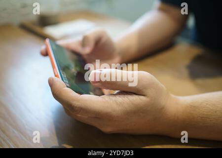 Man playing game on mobile phone. gamer boy playing video games holding SmartphoneÂ working mobile devices. cell telephone techn Stock Photo