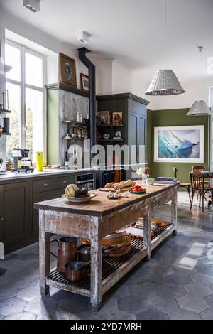 Food preparation on wooden table in olive green kitchen of updated luxury villa in South of France. Stock Photo
