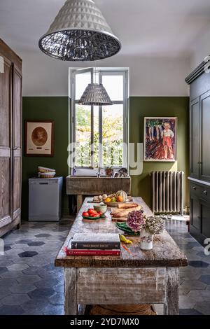 Food preparation on wooden table in olive green kitchen of updated luxury villa in South of France. Stock Photo