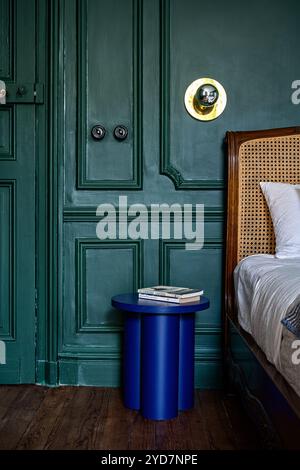 bright blue bedside table in teal panelled bedroom of luxury villa in South of France. Stock Photo