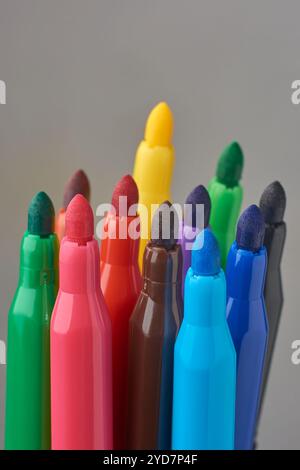 bunch of colorful felt tip or fiber tip pens uncapped isolated gray background, tools for vibrant writing, drawing and crafting, mock-up template Stock Photo