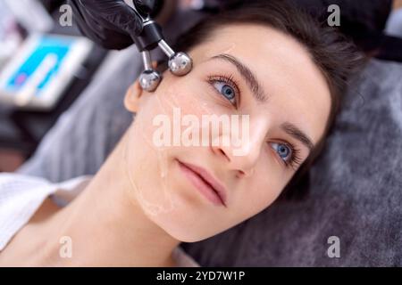 Cosmetology light equipment. Anti age and wrinkle. Microcurrent medicine treatment. Portrait of beautiful woman. Skincare clinic Stock Photo