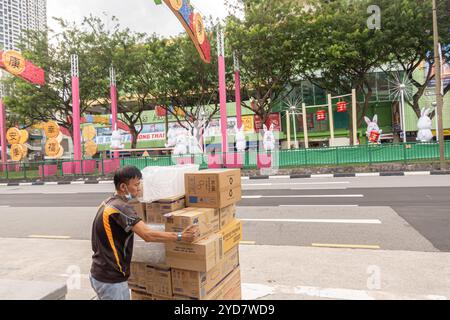 Chinese man carrying carton cardboard boxes in Chinatown Singapore Stock Photo