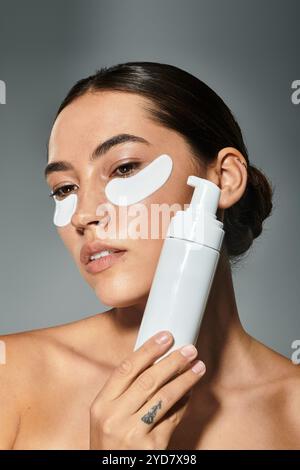 A woman engages in a relaxing skincare routine while holding a beauty product close to her face. Stock Photo