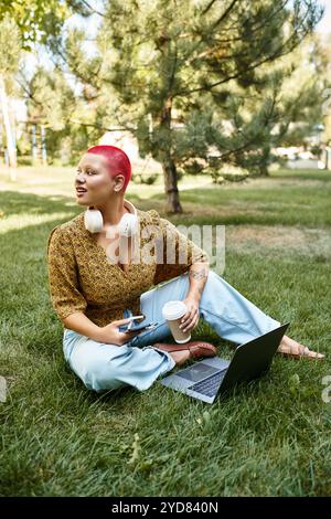 A joyful bald woman enjoys her time outdoors, using technology while sipping coffee. Stock Photo