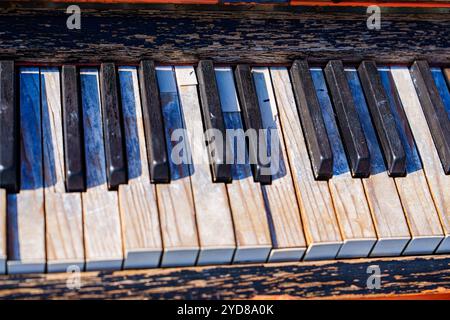 Piano keys close up of old vintage retro piano with peeling white ivory keys and black ebony keys Stock Photo