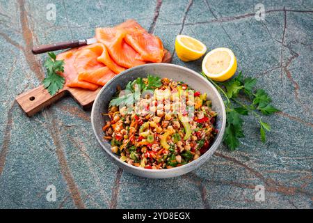 Traditional Norwegian smoked salmon with wild rice salad served as close-up on a rustic wooden chopping board with text space Stock Photo