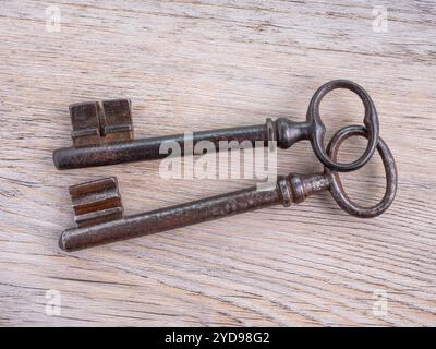 Two vintage iron keys on a wooden background. View from above. Stock Photo