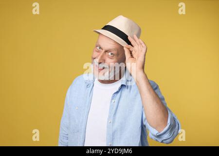 Portrait of happy senior man on yellow background Stock Photo