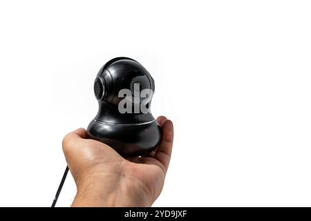 A man is holding a black camera. CCTV camera isolated on white background. Stock Photo