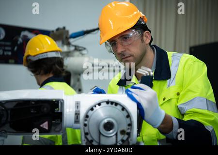 A big welding robot is being inspected and controlled by a robotics engineer. After the machine has been used for the specified Stock Photo