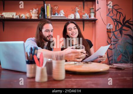Two young entrepreneurs who own a pottery business. We are discussing the container that the customer wants to be molded. to be Stock Photo