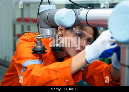 In an electronic parts facility, Female engineers In the plant, inspecting and testing robotic hands used in the production of e Stock Photo