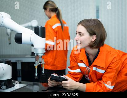 In an electronic parts facility, two female engineers In the plant, inspecting and testing robotic hands used in the production Stock Photo