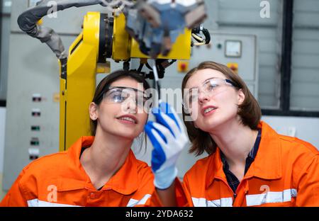 In an electronic parts facility, two female engineers In the plant, inspecting and testing robotic hands used in the production Stock Photo
